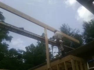 Carpenter setting a ridge beam over a new addition frame — Ice Dam Removal by Roofing Brothers in Herreid