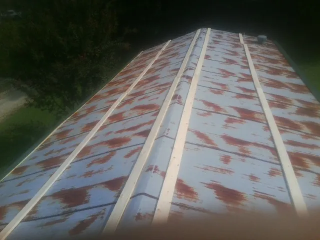 Rusted metal roof panels with new wood purlins before replacement — Storm Damage Roof Repair in Herreid by Roofing Brothers