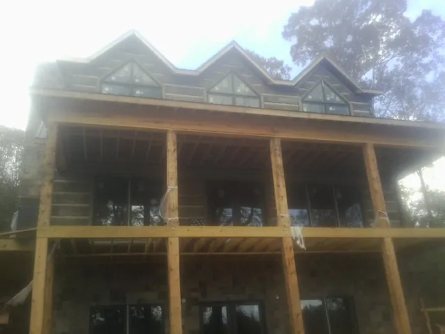 Dormers and porch framing on a large log home under construction — Roof Coating work by our crew in Herreid