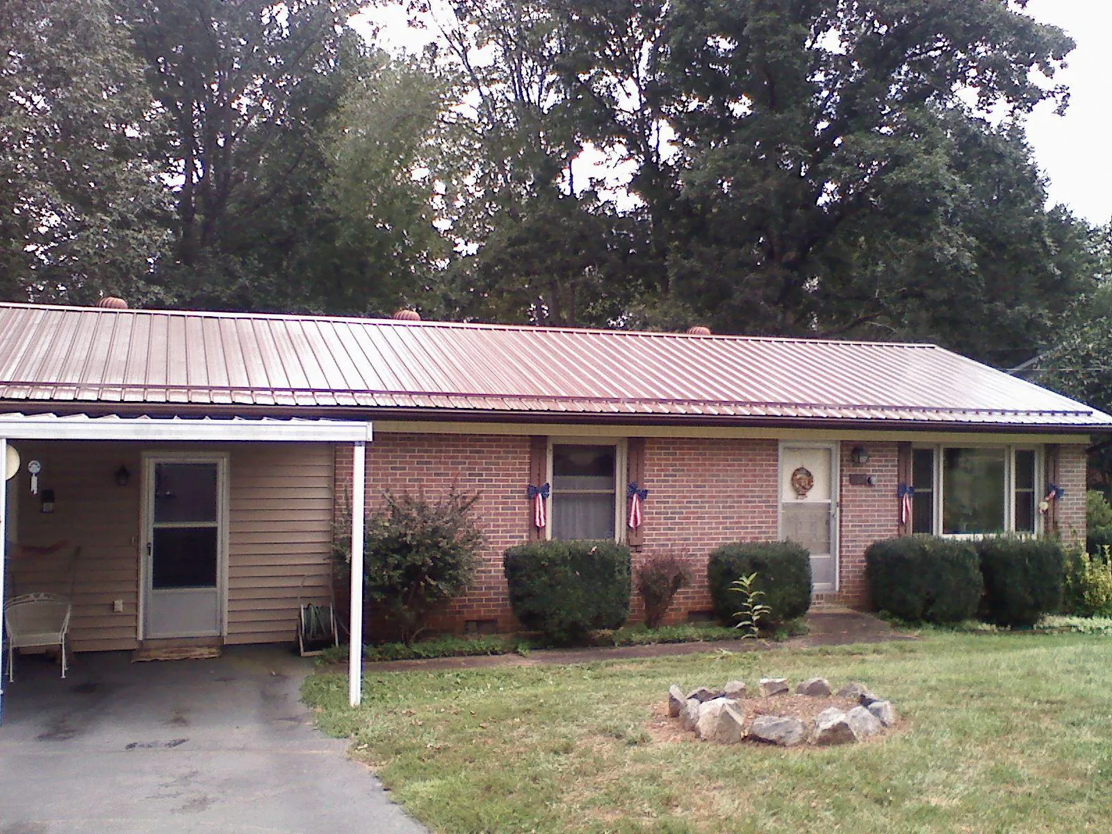 Bronze metal roof and carport on a brick ranch home — Roof Repair work by our crew in Herreid